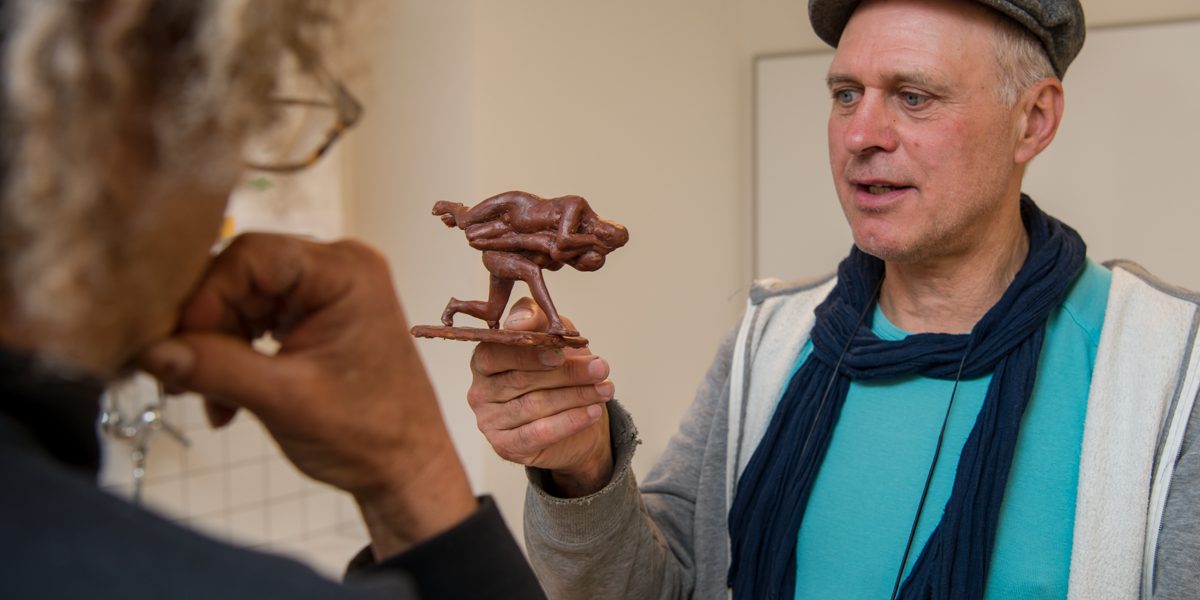 Adelbert Heil stellt seinen in Wachs modellierten Entwurf einem Besucher vor. Foto: Thomas Ochs