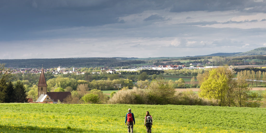Wanderer auf dem Sieben-Flüsse-Wanderweg von Trailsdorf nach Seußling mit Blick auf das Regnitztal und die Fränkische Schweiz. Foto: Andreas Hub Wanderer auf dem Sieben-Flüsse-Wanderweg von Trailsdorf nach Seußling mit Blick auf das Regnitztal und die Fränkische Schweiz. Foto: Andreas Hub