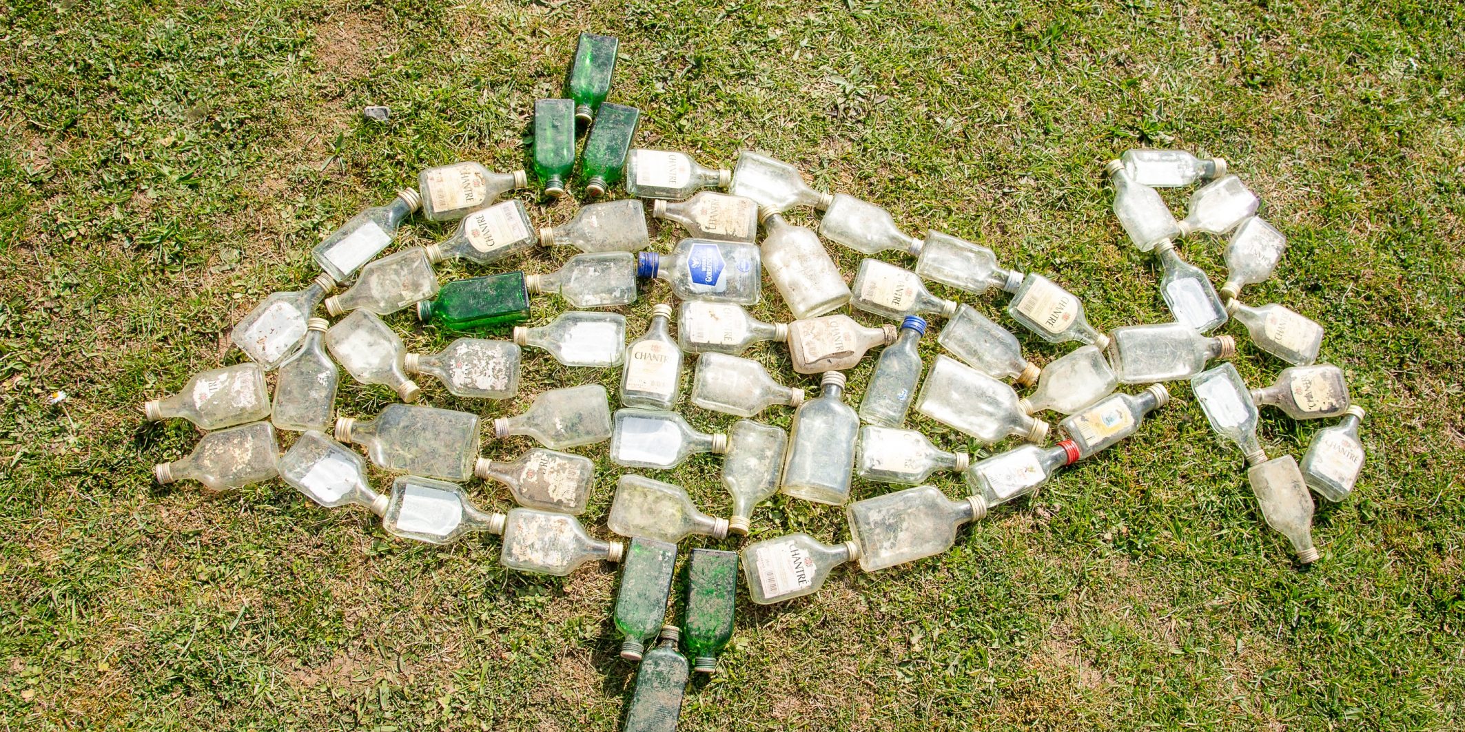 Die beim Müll-Sammeln gefundenen Glasflaschen haben die Kinder in Form eines Fisches arrangiert. Danach wandern die Flaschen in den Container fürs Recycling. Foto: Thomas Ochs Die beim Müll-Sammeln gefundenen Glasflaschen haben die Kinder in Form eines Fisches arrangiert. Danach wandern die Flaschen in den Container fürs Recycling. Foto: Thomas Ochs