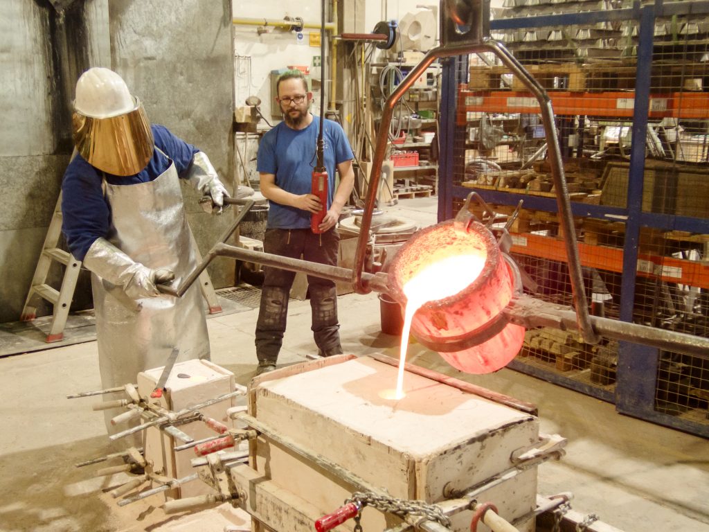 Über 1.000 Grad heiße, glühende Bronze wird in die vorbereitete Form gegossen. Foto: Anne Schmitt