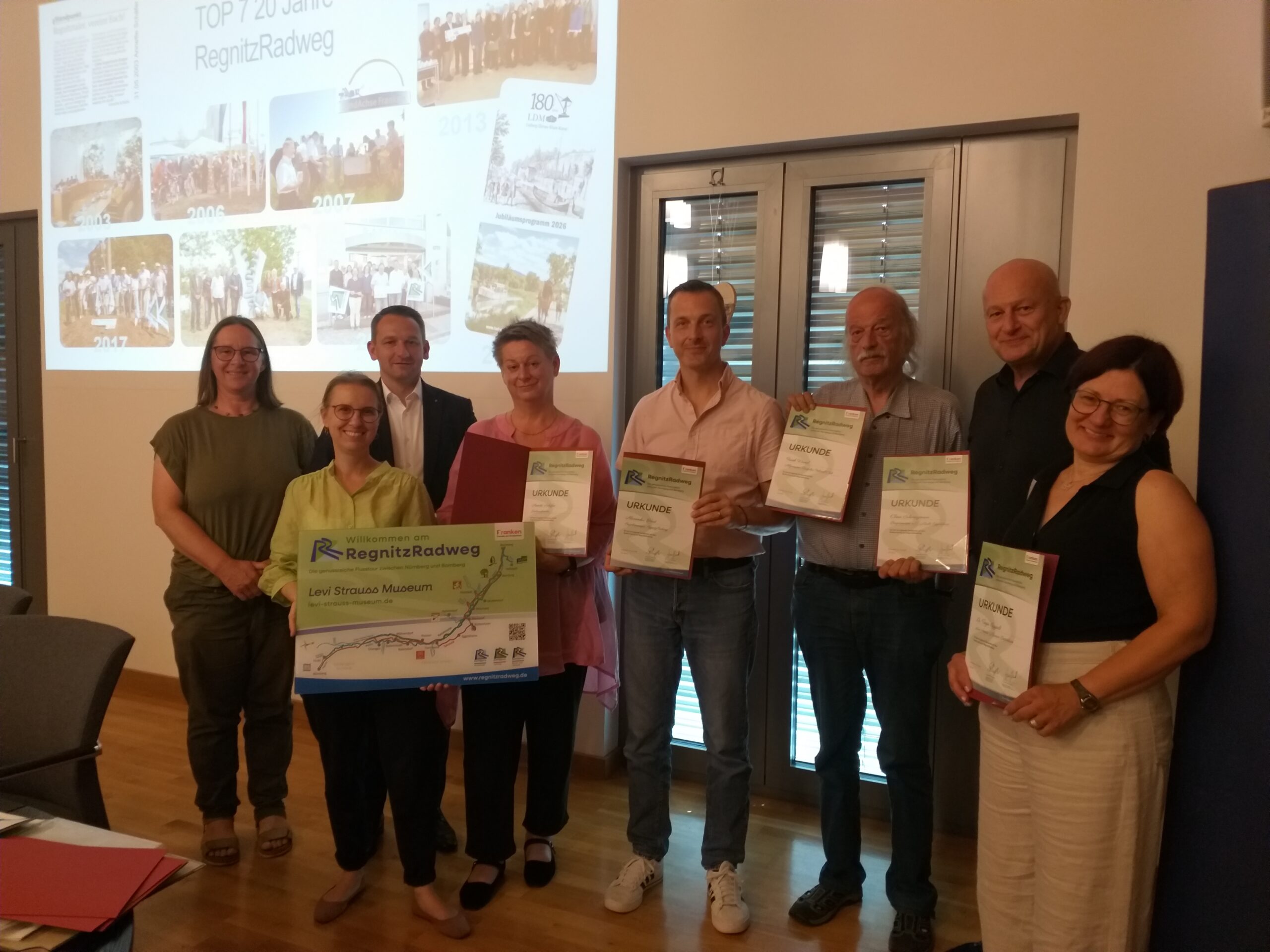 v.l.n.r. Dr. Anne Schmitt Geschäftsführerin Flussparadies Franken, Buttenheims Bürgermeisterin Dr. Stephanie Auer-Neuberg mit der Partner-Tafel RegnitzRadweg für das Levi-Strauss Museum und Landrat Johannes Maciejonczyk (Lkr. Bamberg). Er ehrte als neuer Vorsitzender des Flussparadieses Franken Personen, die in besonderer Weise am Erfolg des RegnitzRadwegs beteiligt waren. Eine Urkunde bekamen (v. l. n. r.) Kulturexpertin Annette Schäfer, Alexander Hart (Tourismusverband Franken), Frank Wessel (ADFC), Bürgermeister a.D. Claus Schwarzmann und Dr. Tanja Roppelt (Levi-Strauss-Museum). Nicht auf dem Foto: Ulrike Schaefer (Umweltstation Lias-Grube), Erich Kohler (Bauhof Lkr. Forchheim) und Thomas Reichert (Landratsamt Bamberg). Foto: Bettina Fritzler v.l.n.r. Dr. Anne Schmitt Geschäftsführerin Flussparadies Franken, Buttenheims Bürgermeisterin Dr. Stephanie Auer-Neuberg mit der Partner-Tafel RegnitzRadweg für das Levi-Strauss Museum und Landrat Johannes Maciejonczyk (Lkr. Bamberg). Er ehrte als neuer Vorsitzender des Flussparadieses Franken Personen, die in besonderer Weise am Erfolg des RegnitzRadwegs beteiligt waren. Eine Urkunde bekamen (v. l. n. r.) Kulturexpertin Annette Schäfer, Alexander Hart (Tourismusverband Franken), Frank Wessel (ADFC), Bürgermeister a.D. Claus Schwarzmann und Dr. Tanja Roppelt (Levi-Strauss-Museum). Nicht auf dem Foto: Ulrike Schaefer (Umweltstation Lias-Grube), Erich Kohler (Bauhof Lkr. Forchheim) und Thomas Reichert (Landratsamt Bamberg). Foto: Bettina Fritzler